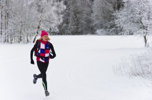 Women jogging through snowy forest.
